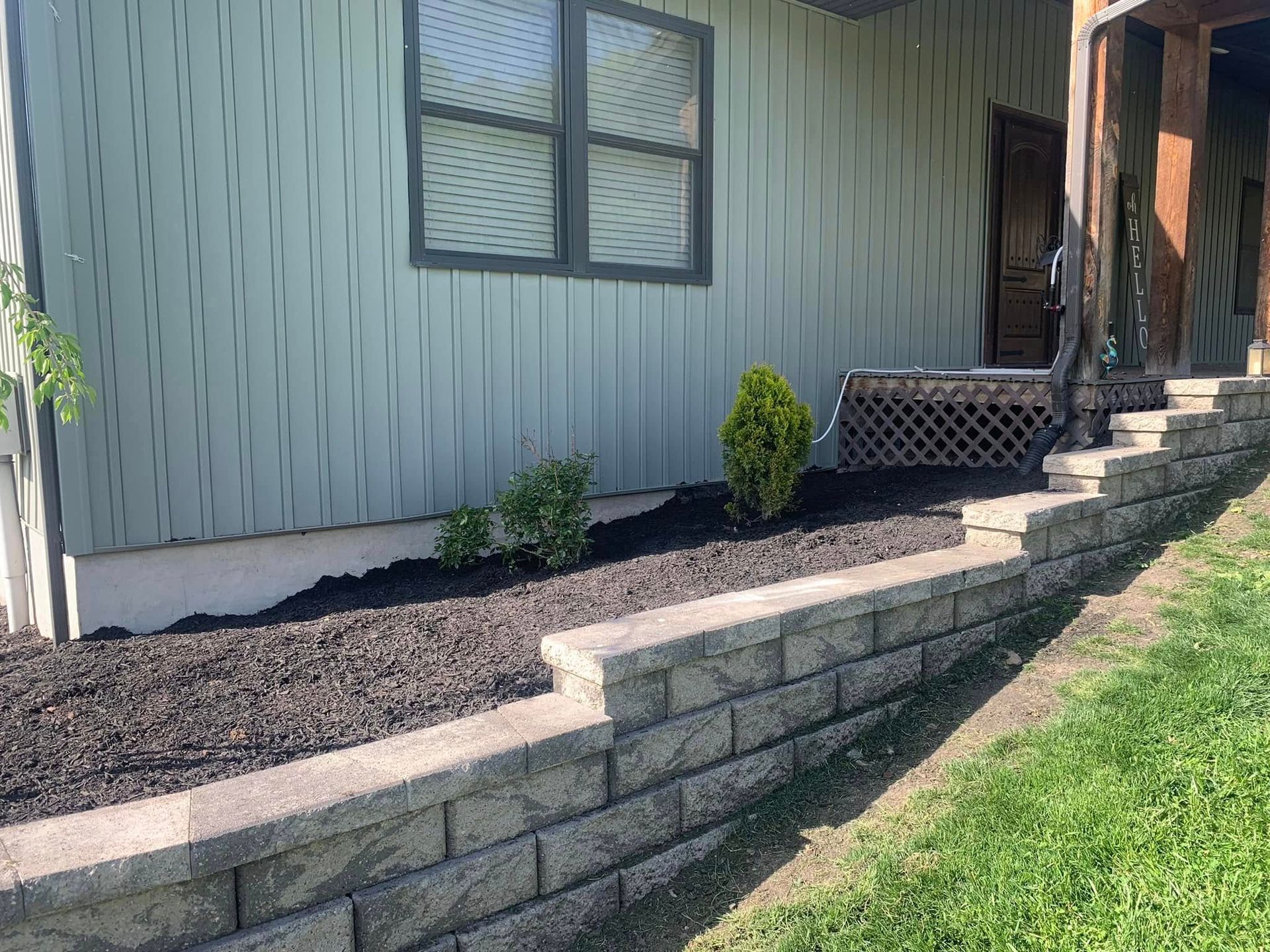 A house with a brick wall in front of it.