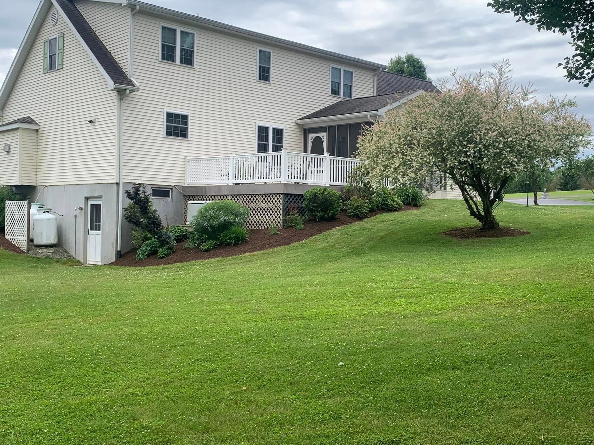 A large white house with a large lawn in front of it.