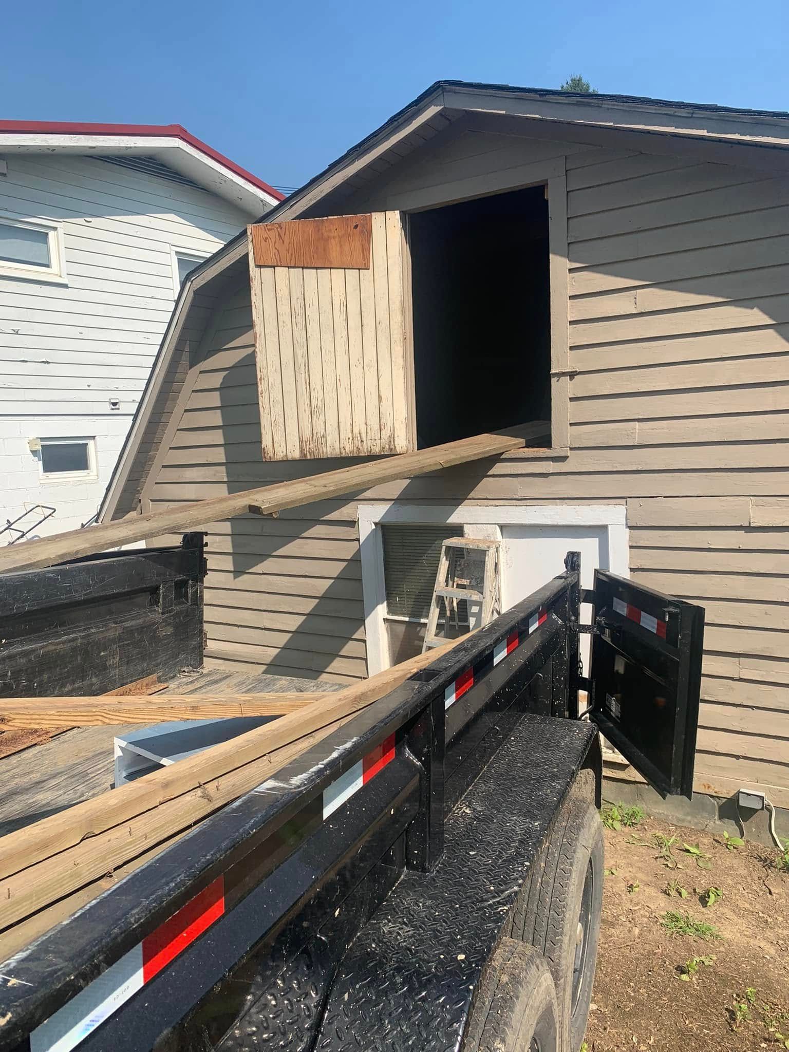A truck is parked in front of a house with a box on top of it.
