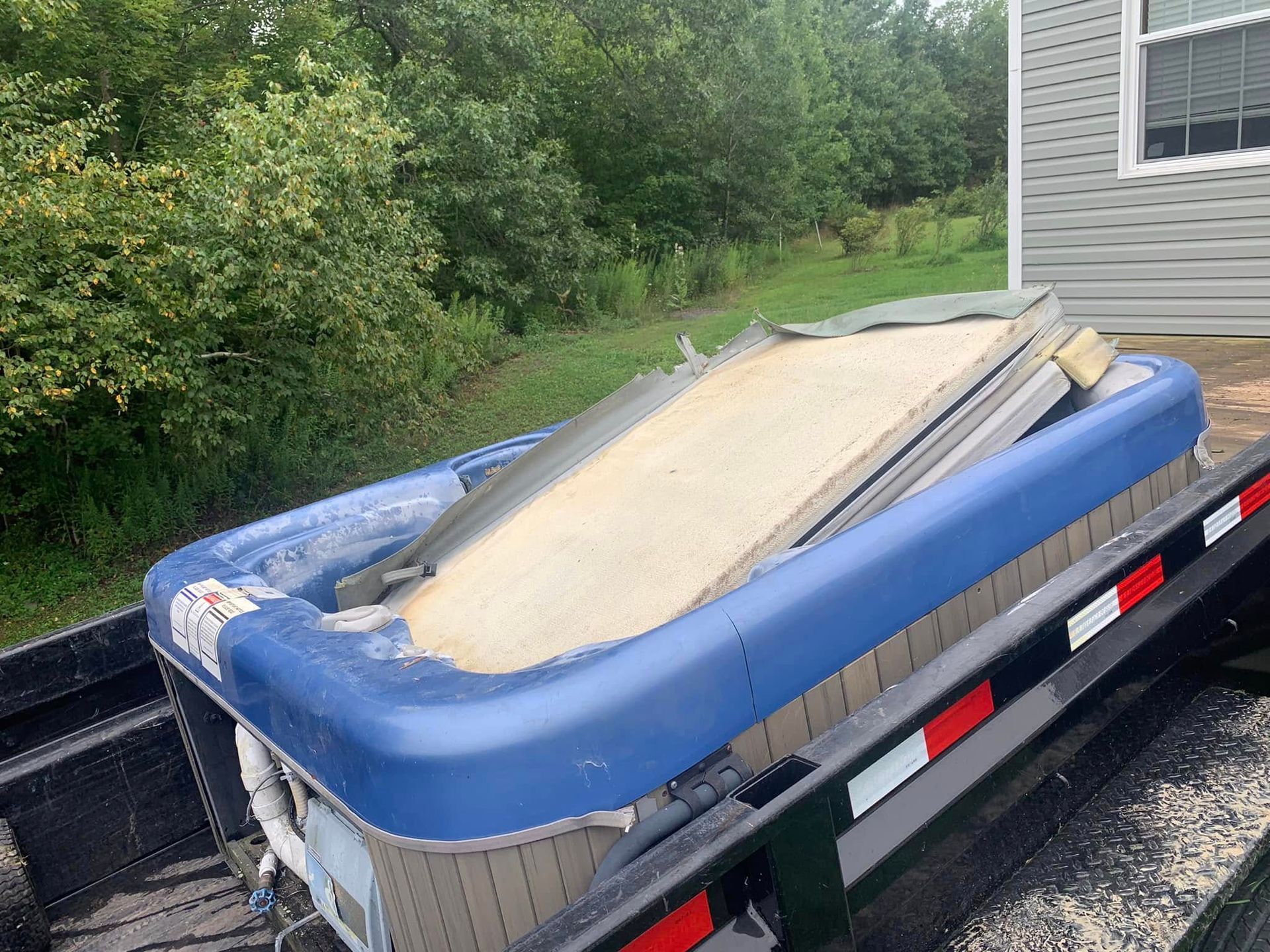 A blue hot tub is sitting on top of a trailer.