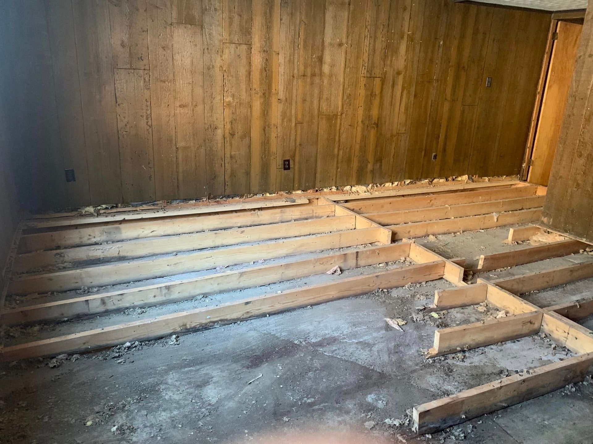 A room with a wooden floor and a wooden wall.