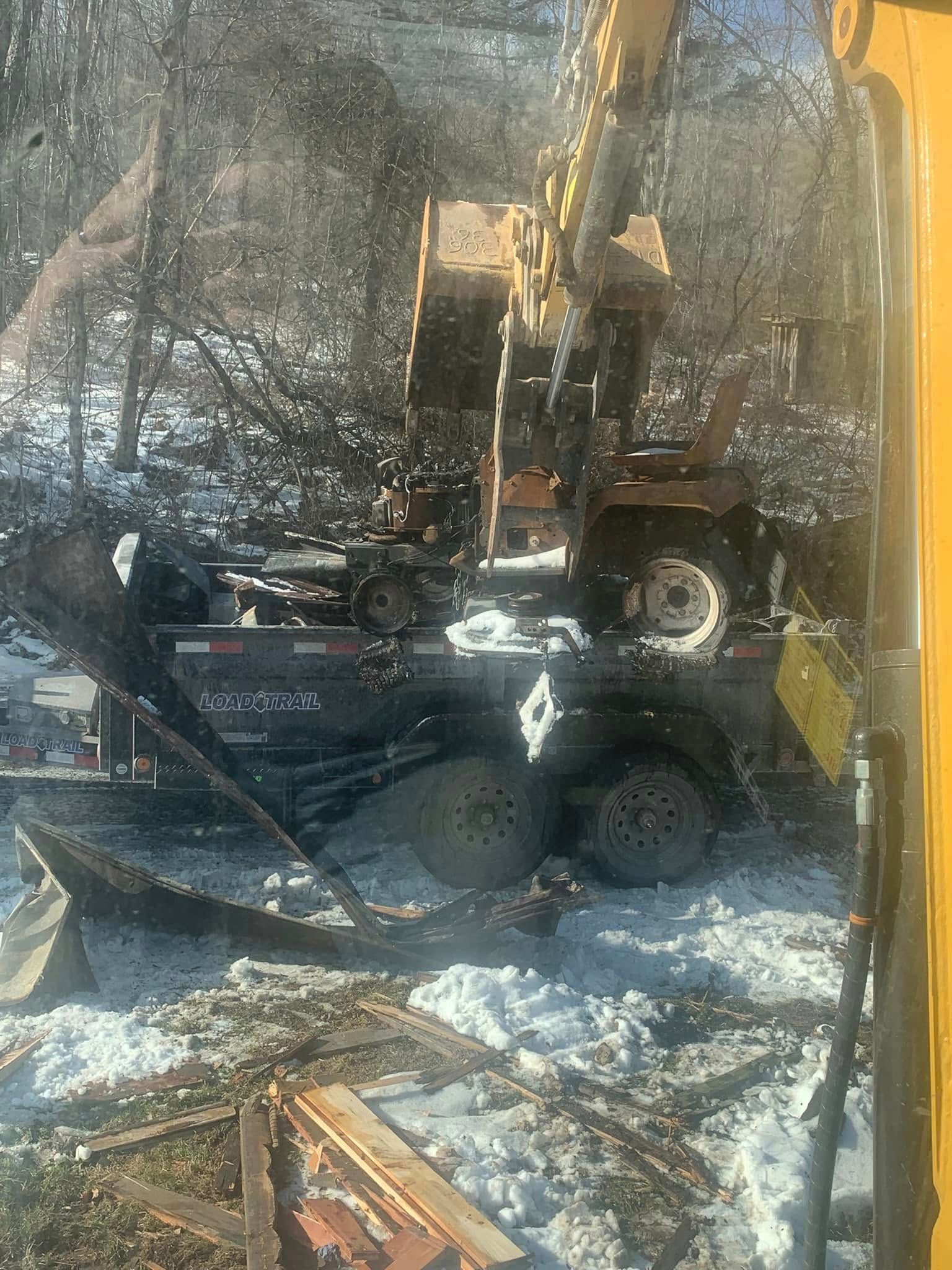 A large yellow excavator is sitting on top of a snow covered field.