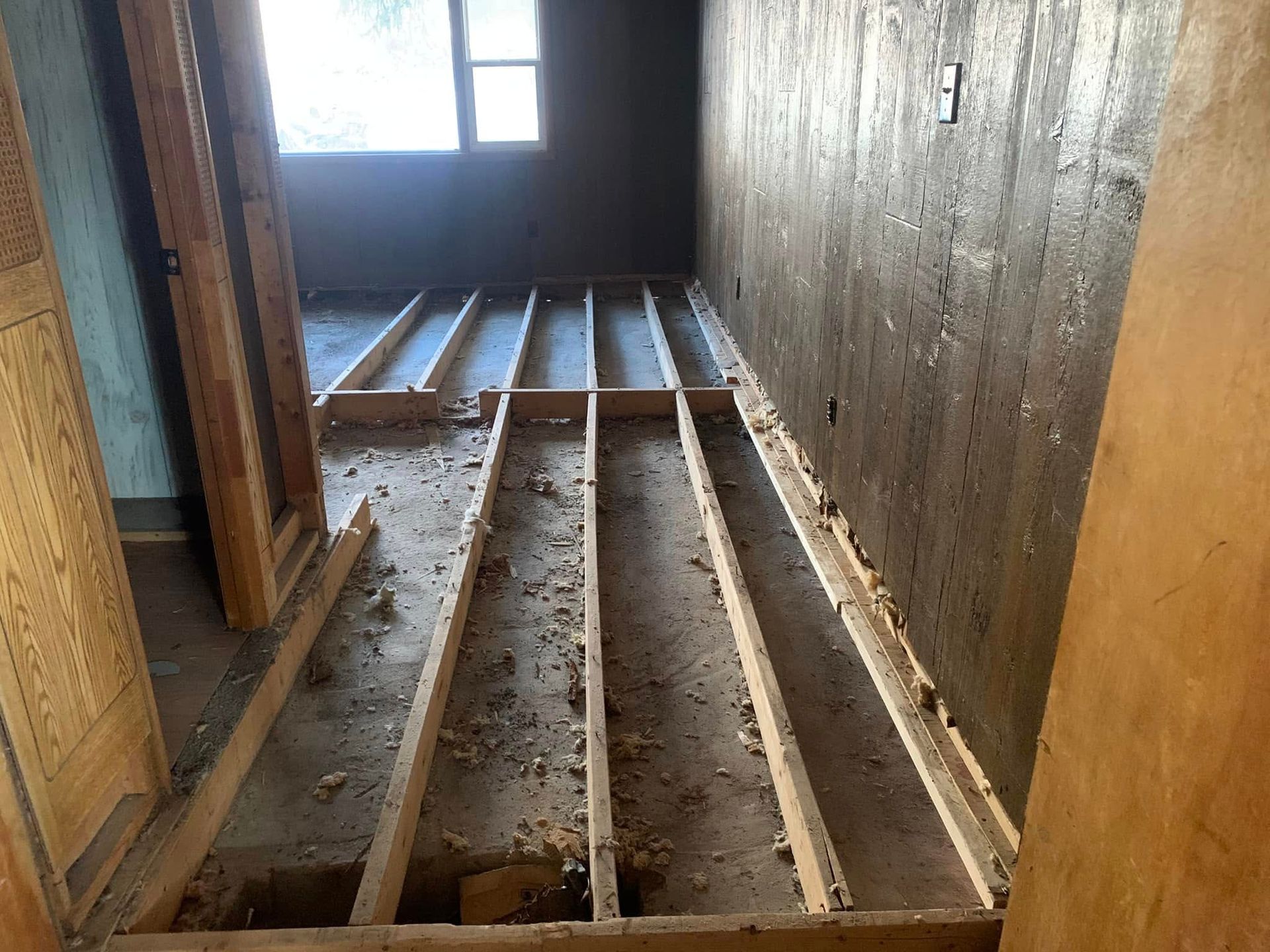 A room with a wooden floor and a concrete wall.