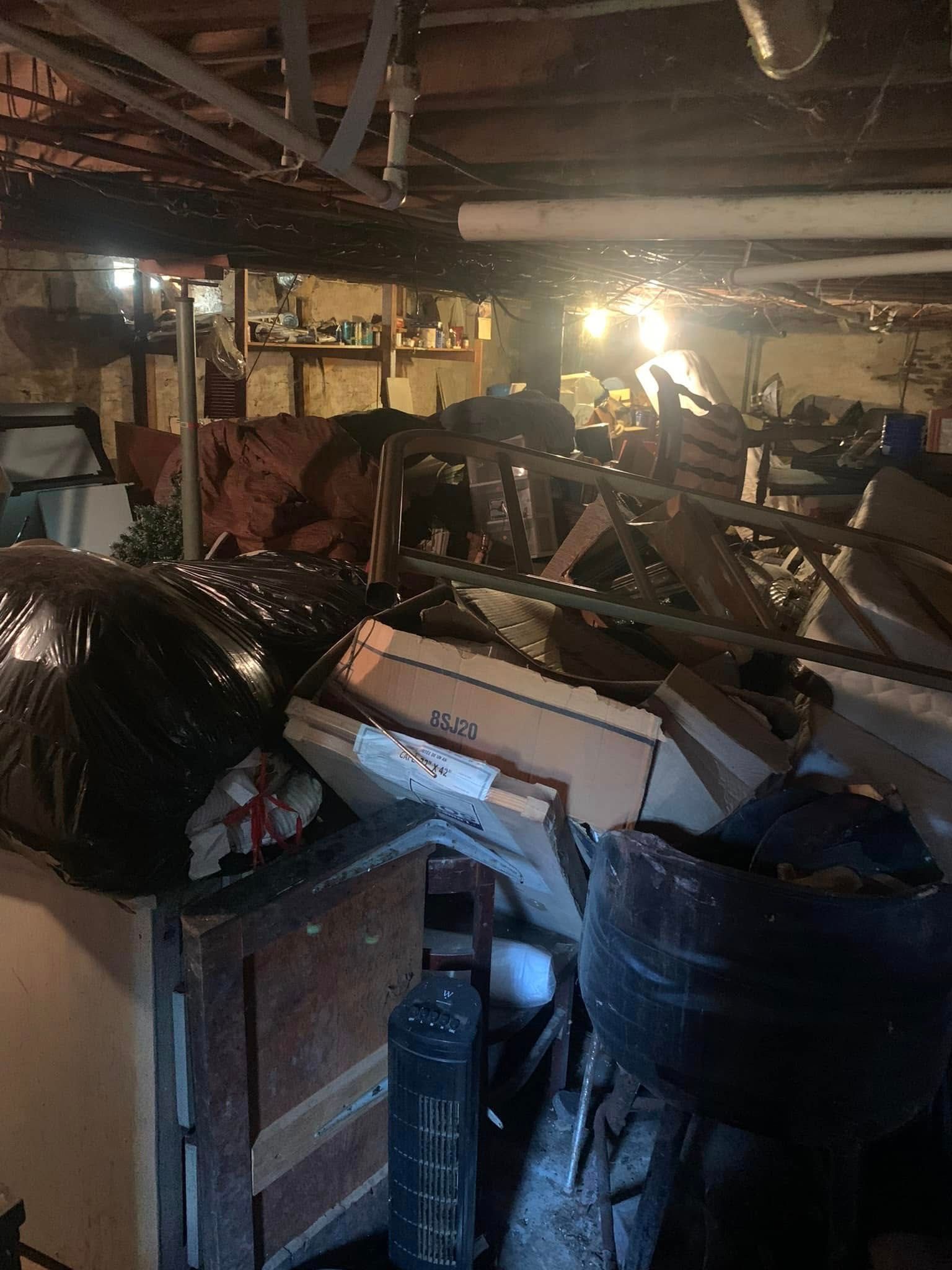 A basement filled with lots of trash and boxes.