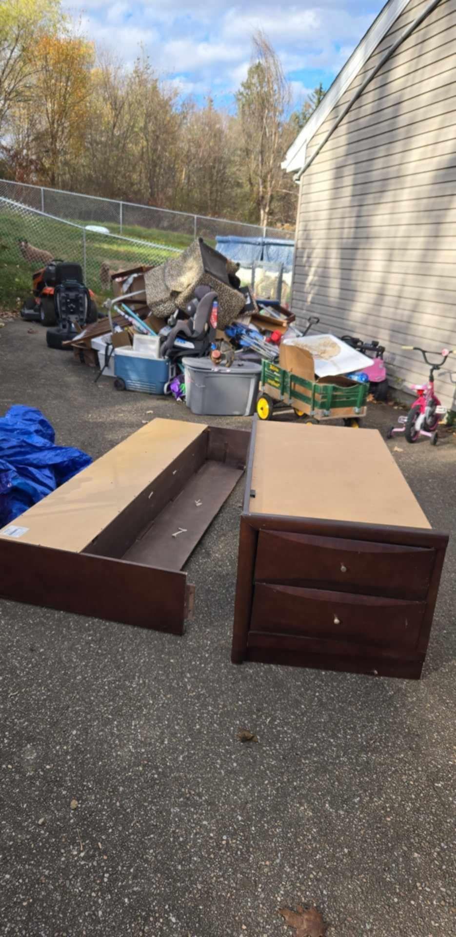 A pile of junk is sitting on the ground in front of a house.