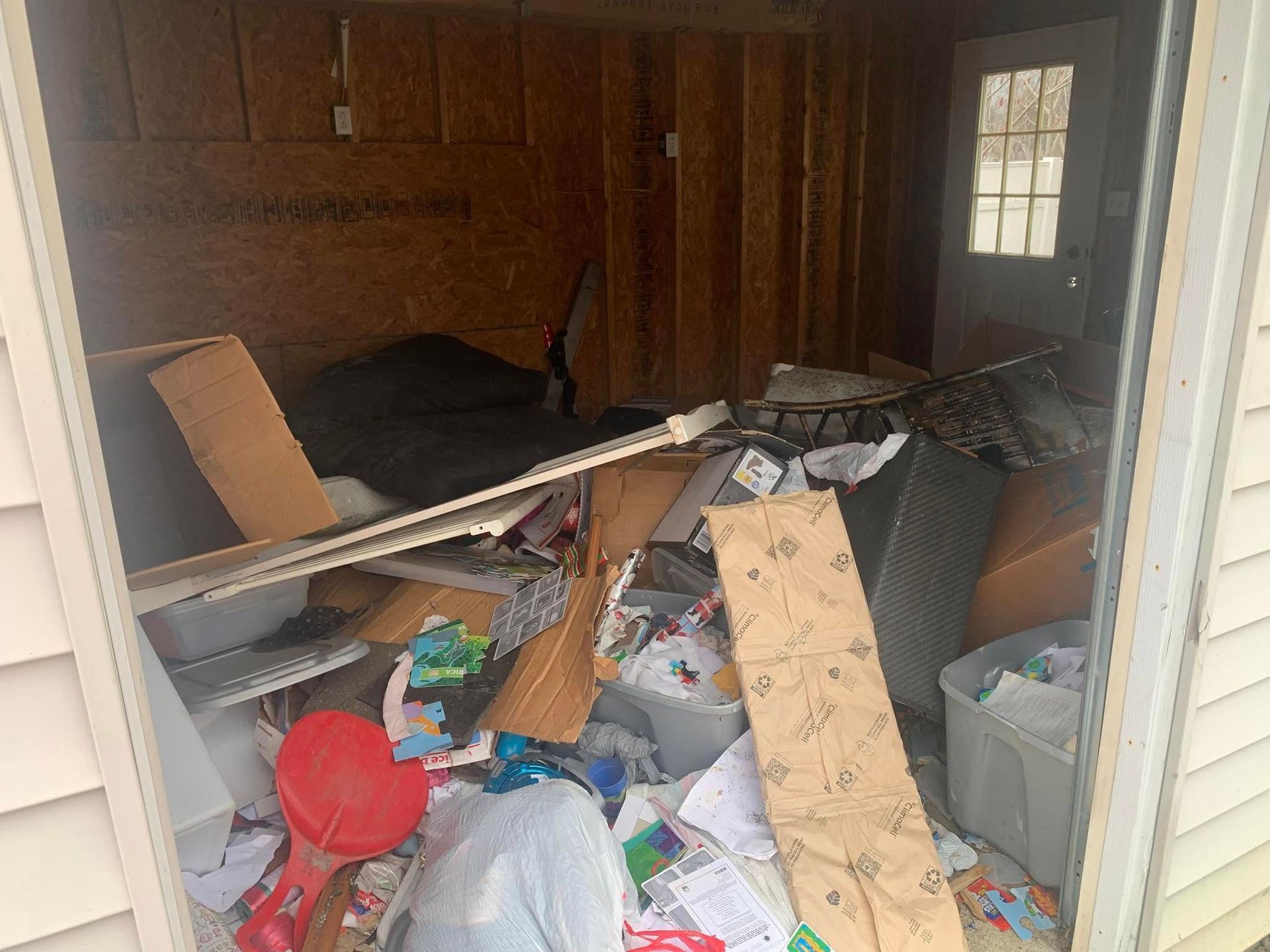 A shed filled with lots of trash and junk.
