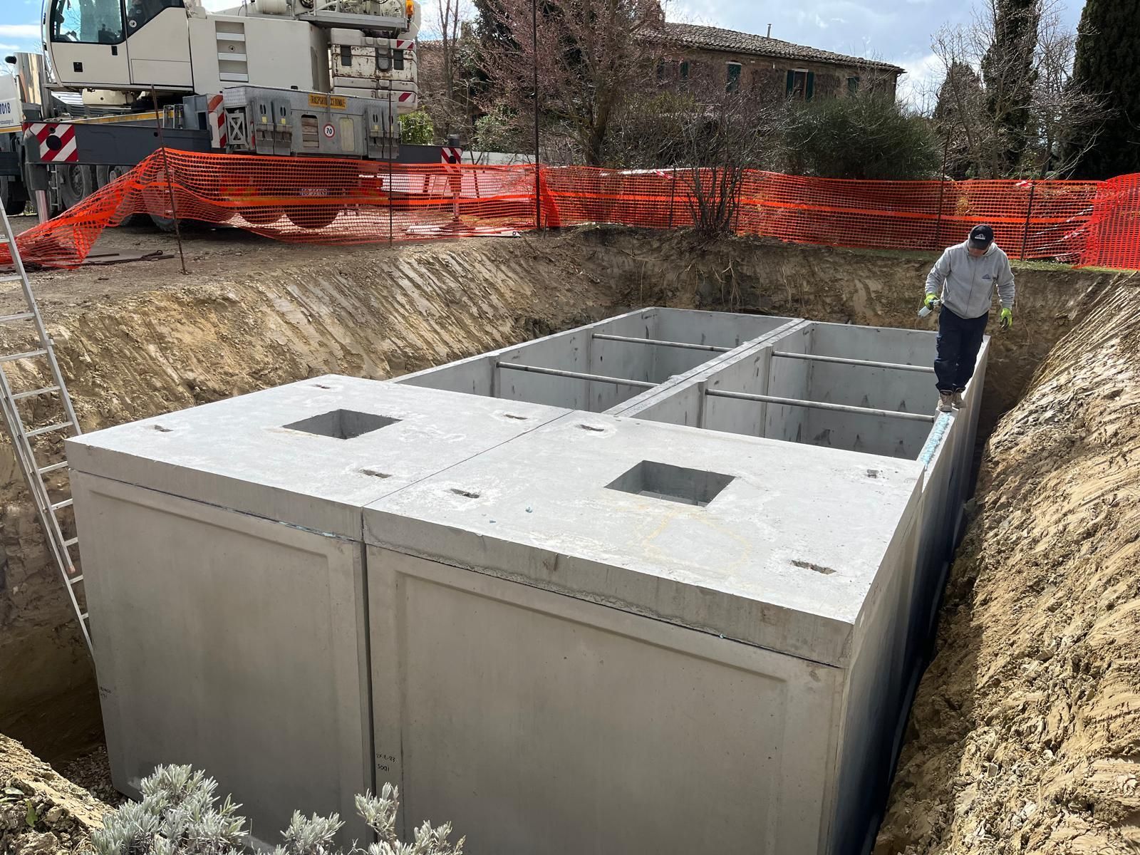 Un uomo è in piedi in una buca accanto a una grande struttura di cemento.