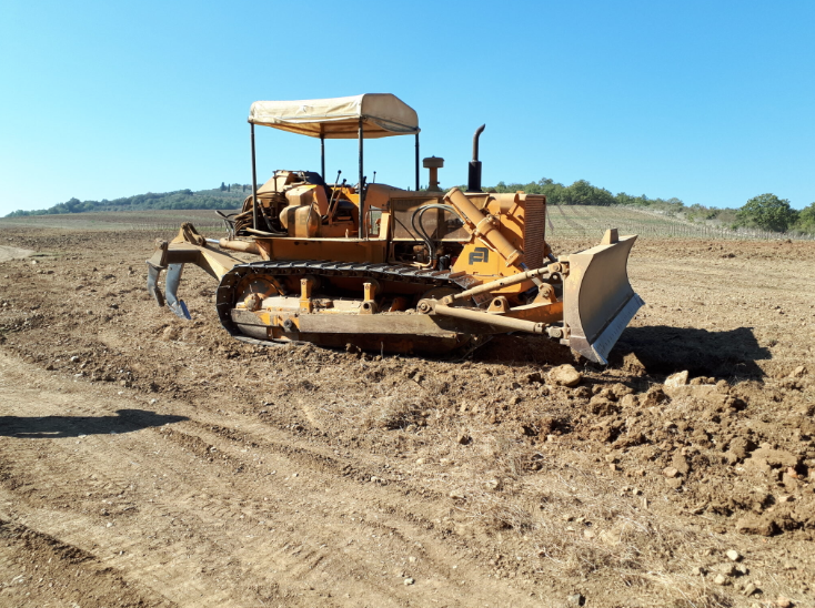 Un bulldozer è fermo in mezzo a un campo sterrato