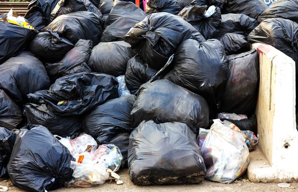 A Pile of Black Garbage Bags on the Side of the Road — Demco in Currumbin Waters, QLD