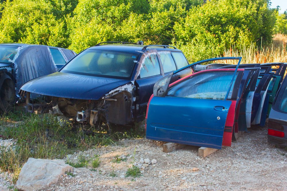 A Bunch of Cars Are Sitting in a Junkyard With Their Doors Open — Demco In Tweed Shire, NSW
