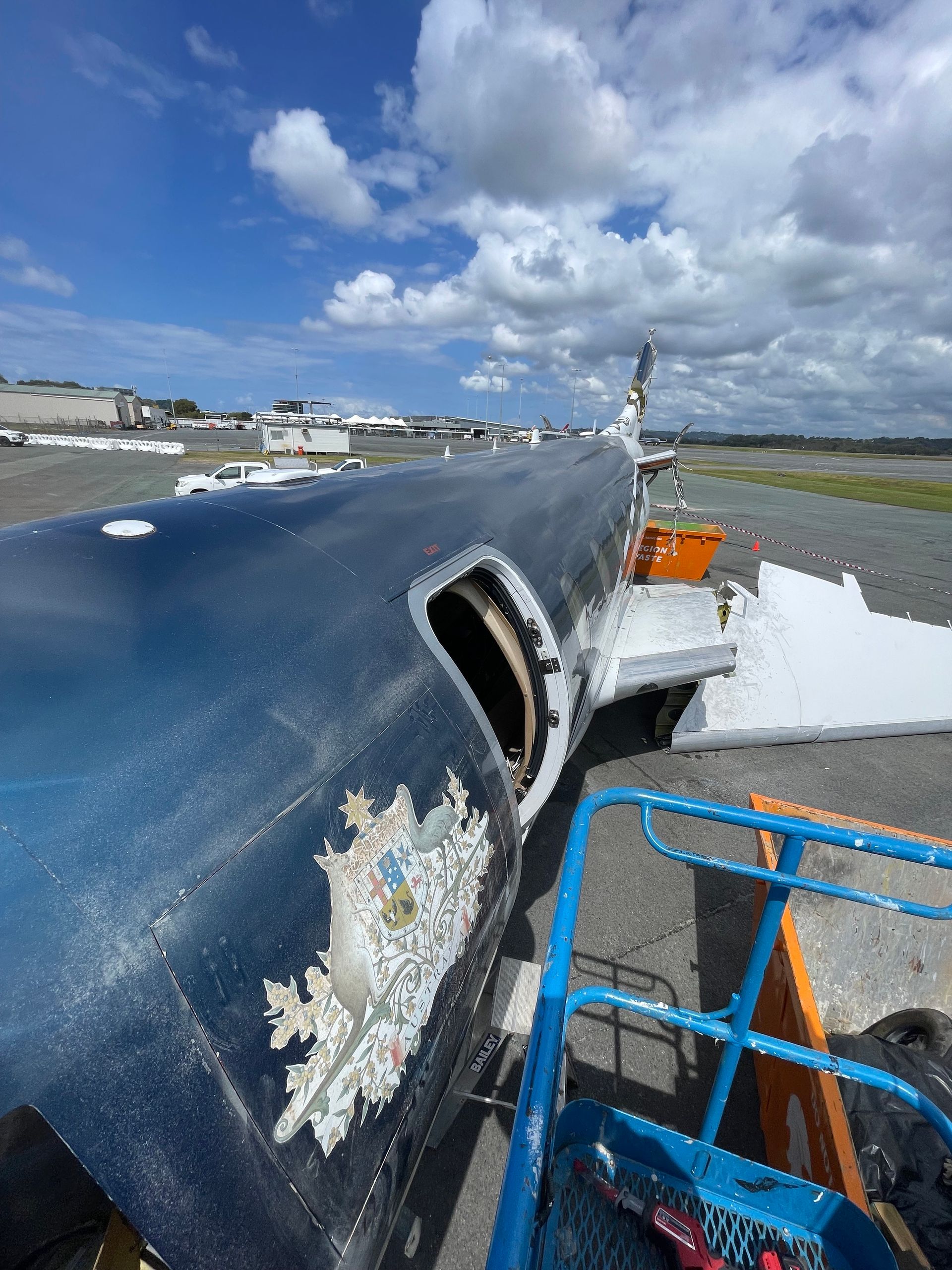 A plane with a hole in the side is sitting on a runway. — Demco In Currumbin Waters, QLD