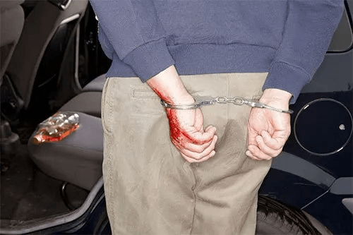 Arrested man in handcuffs with hands behind back
