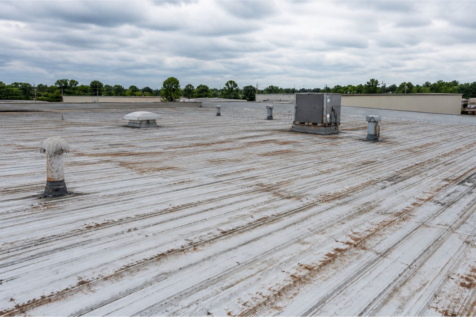Commercial flat roof on a large building in Wisconsin with white roof coating.