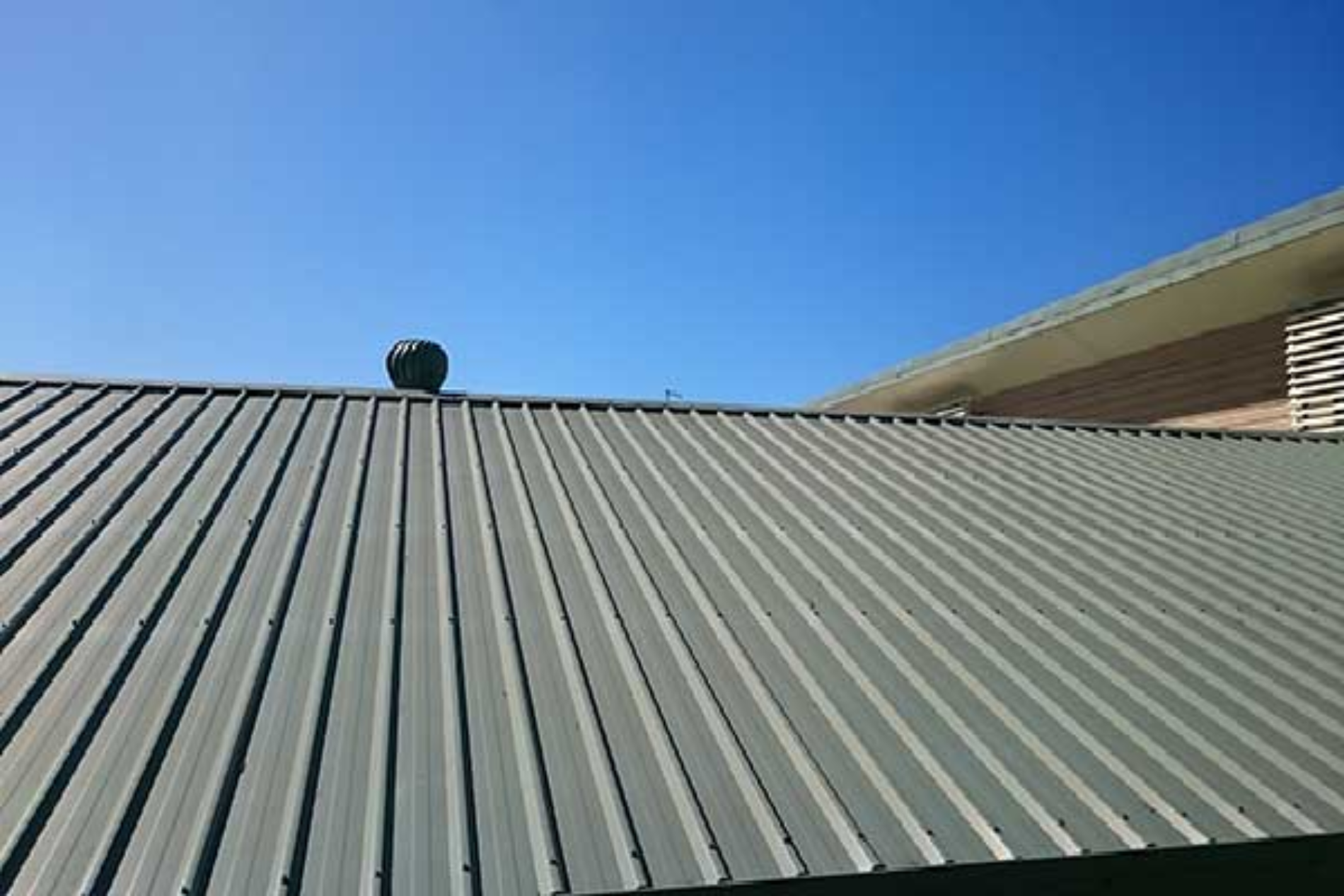 A close up of a roof with a blue sky in the background.