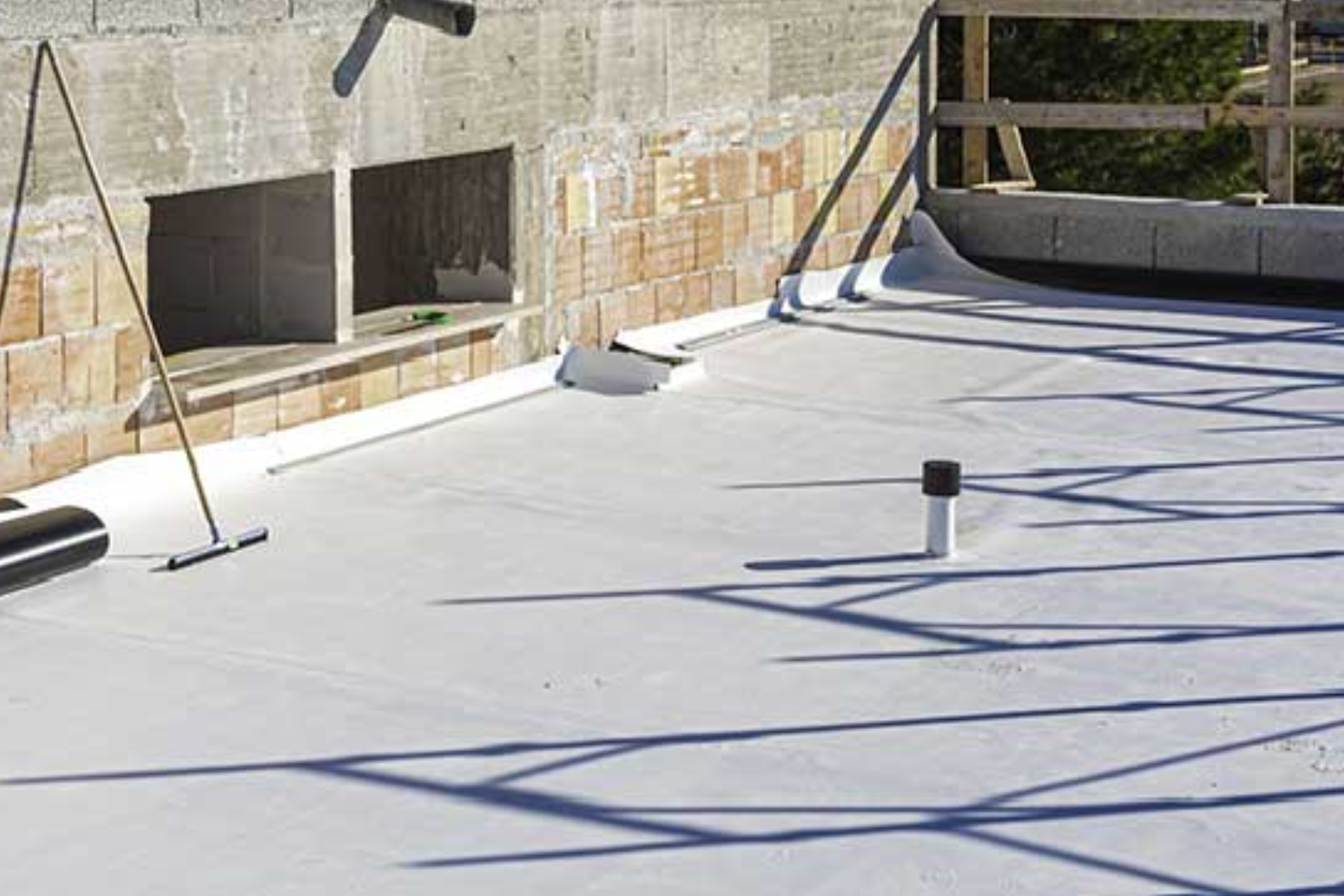 A roof with a pipe and a broom on it.