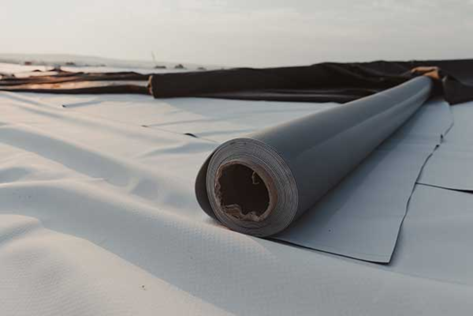 A roll of roofing material is sitting on top of a roof.