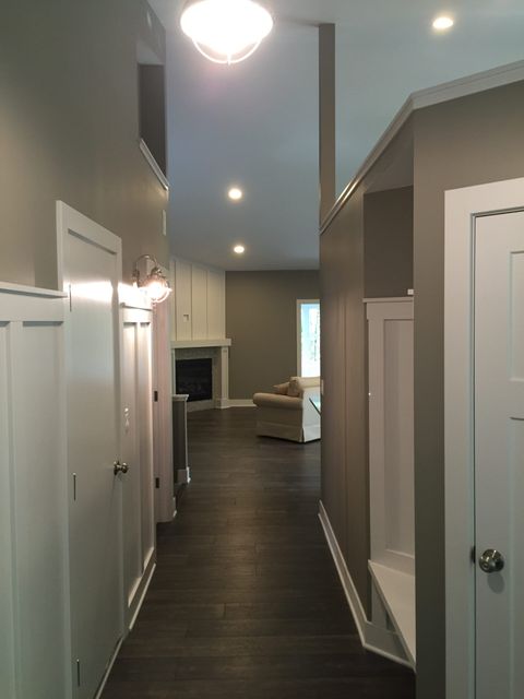 A long hallway leading to a living room and a fireplace.