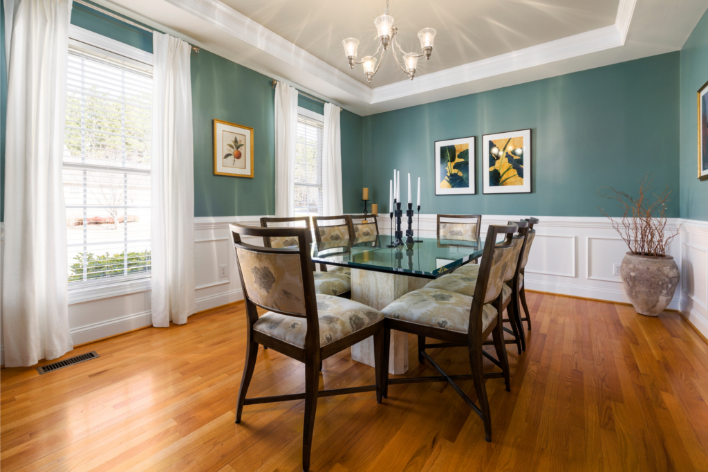 A dining room with a glass table and chairs and a chandelier.