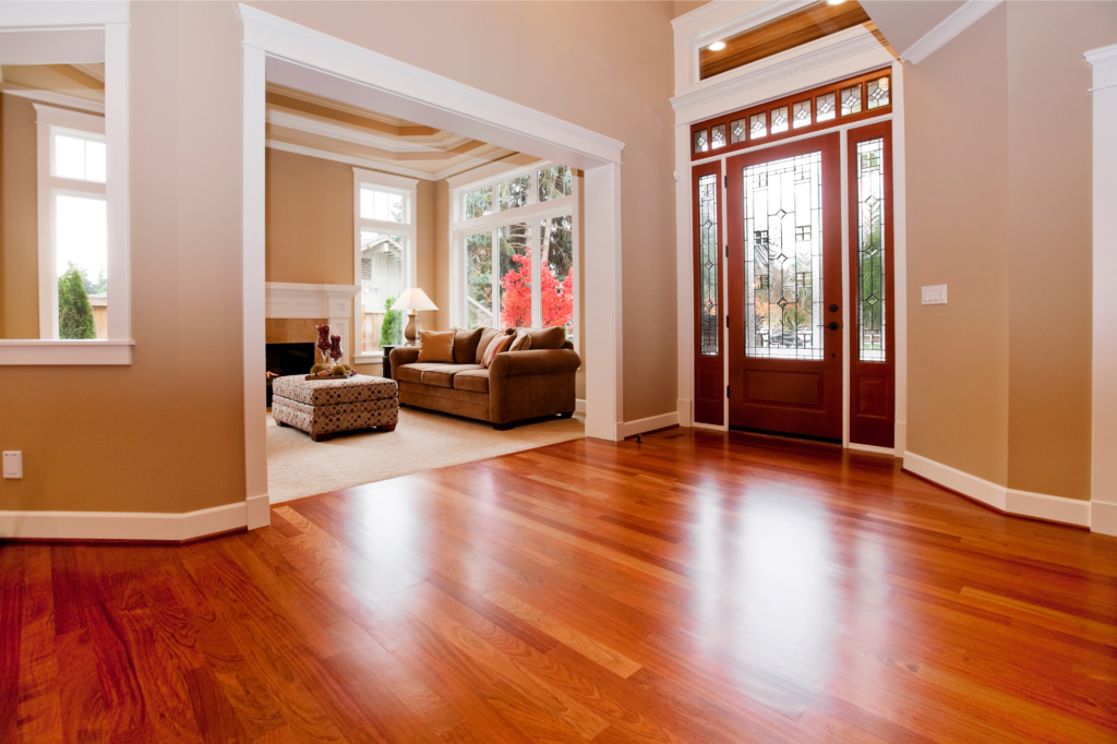An empty living room with hardwood floors and a couch.