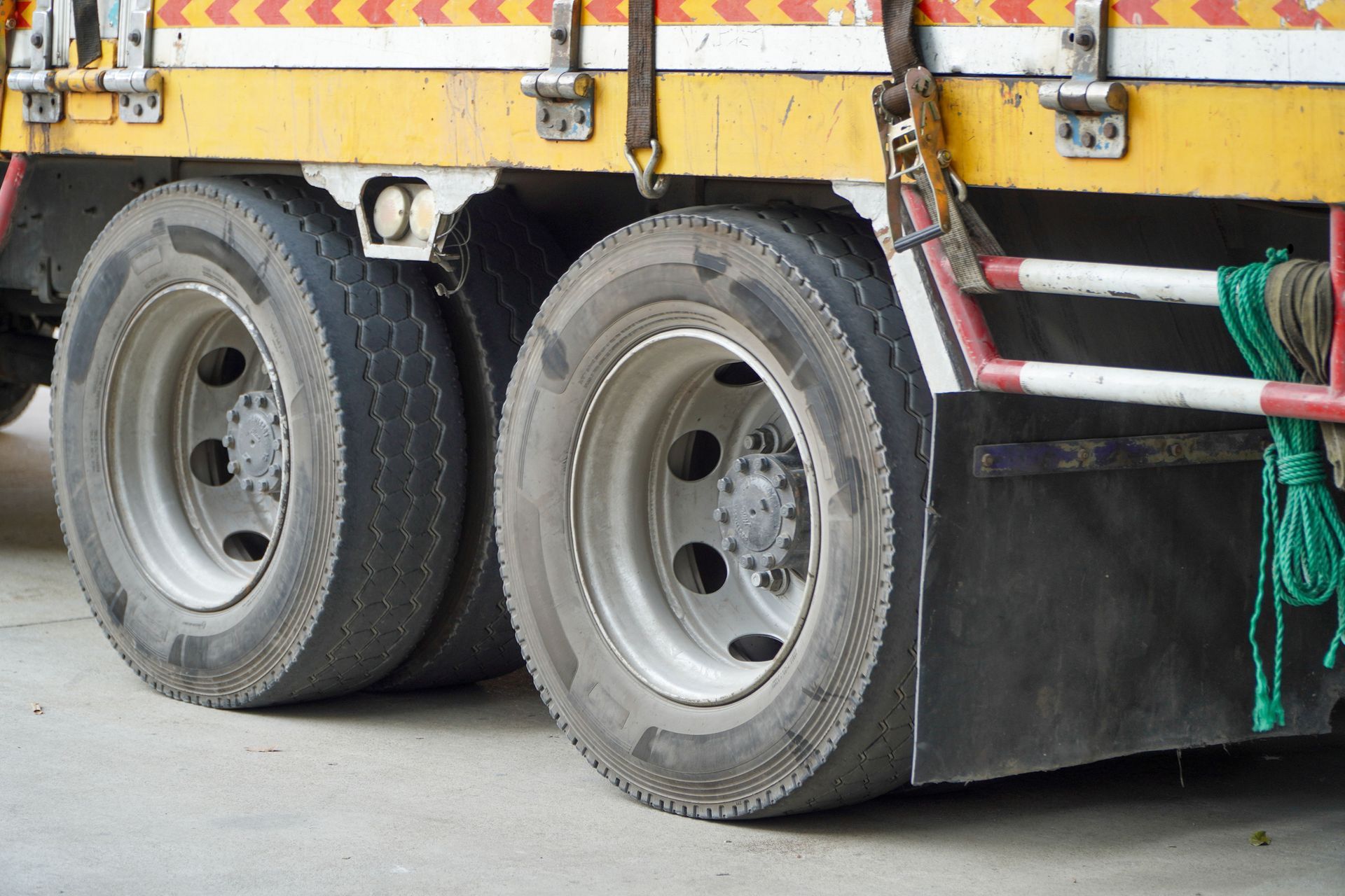 Two rear truck tires on an industrial vehicle, showing tread and metal rim, close-up detail.