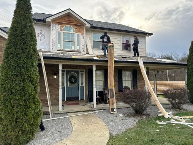 A man and a woman are standing in front of a house under construction.