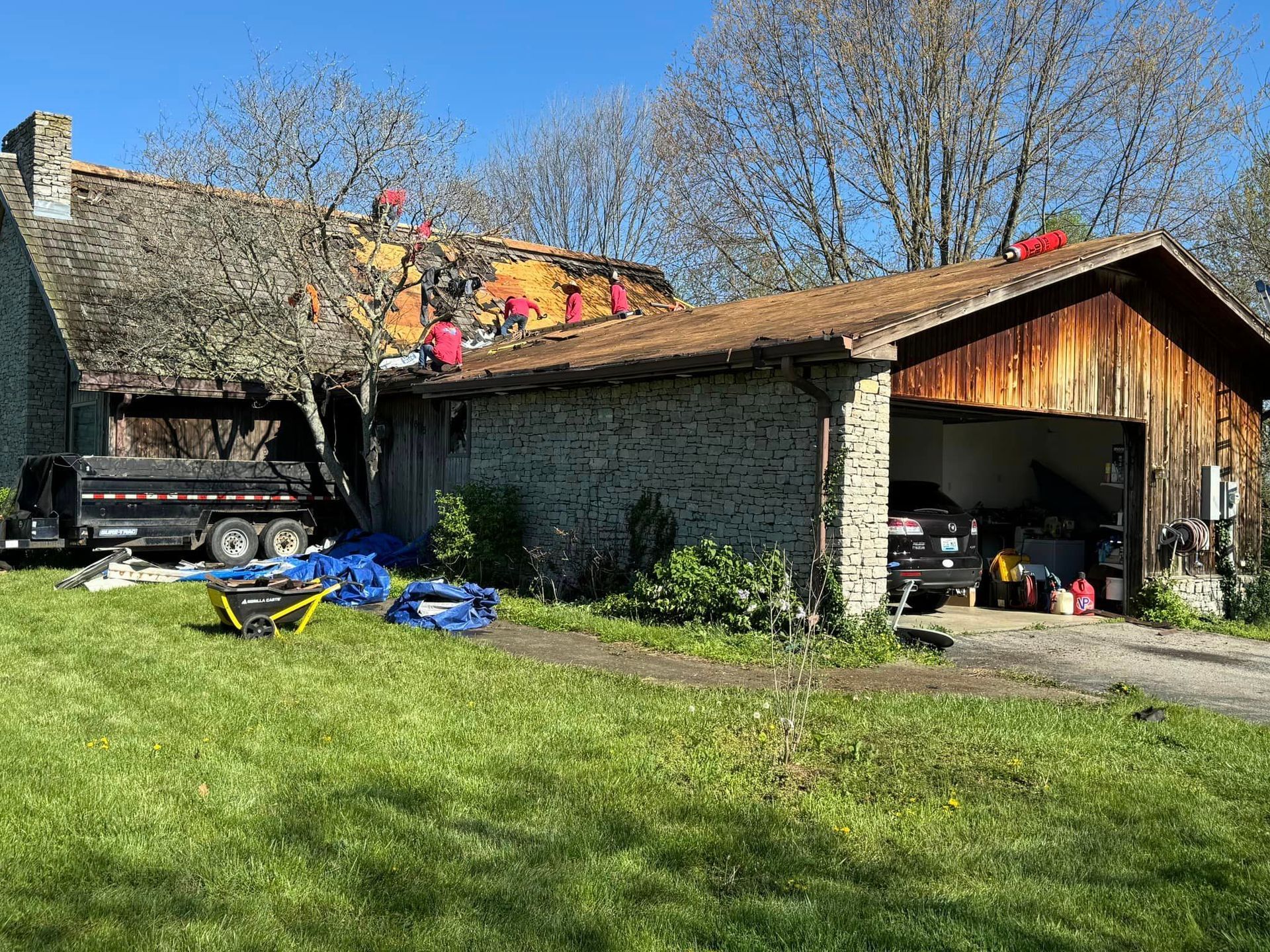 A house with a wooden garage and a truck parked in front of it.