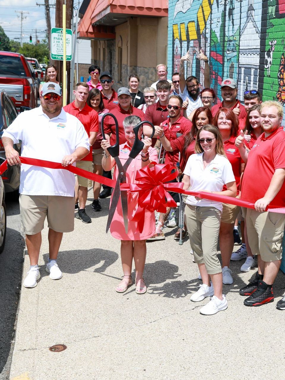 A group of people are posing for a picture in front of a red truck.