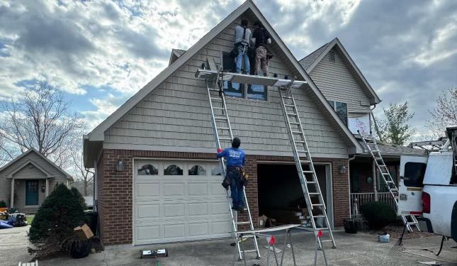 A man is standing on a ladder in front of a house.