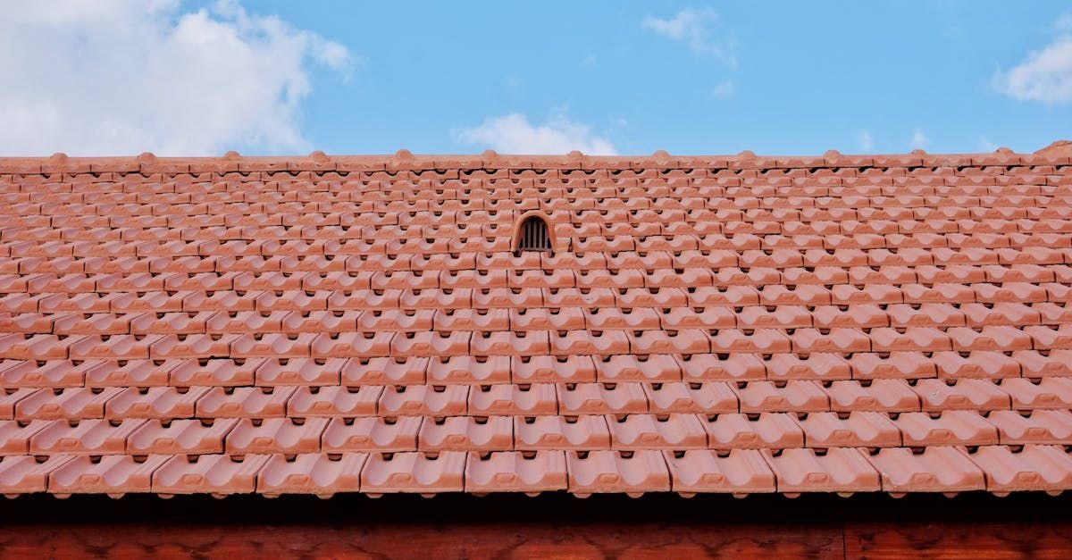 A red tiled roof with a hole in the middle and a blue sky in the background.