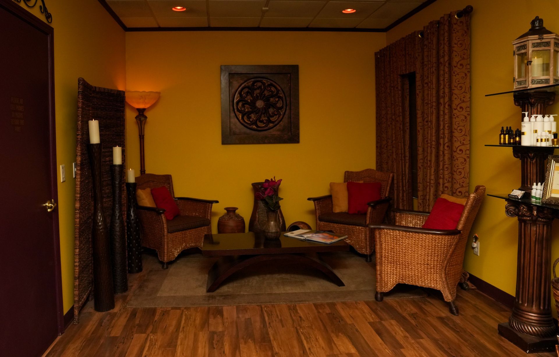 Cozy seating area with wicker chairs, warm lighting, and decorative curtains and wall art.