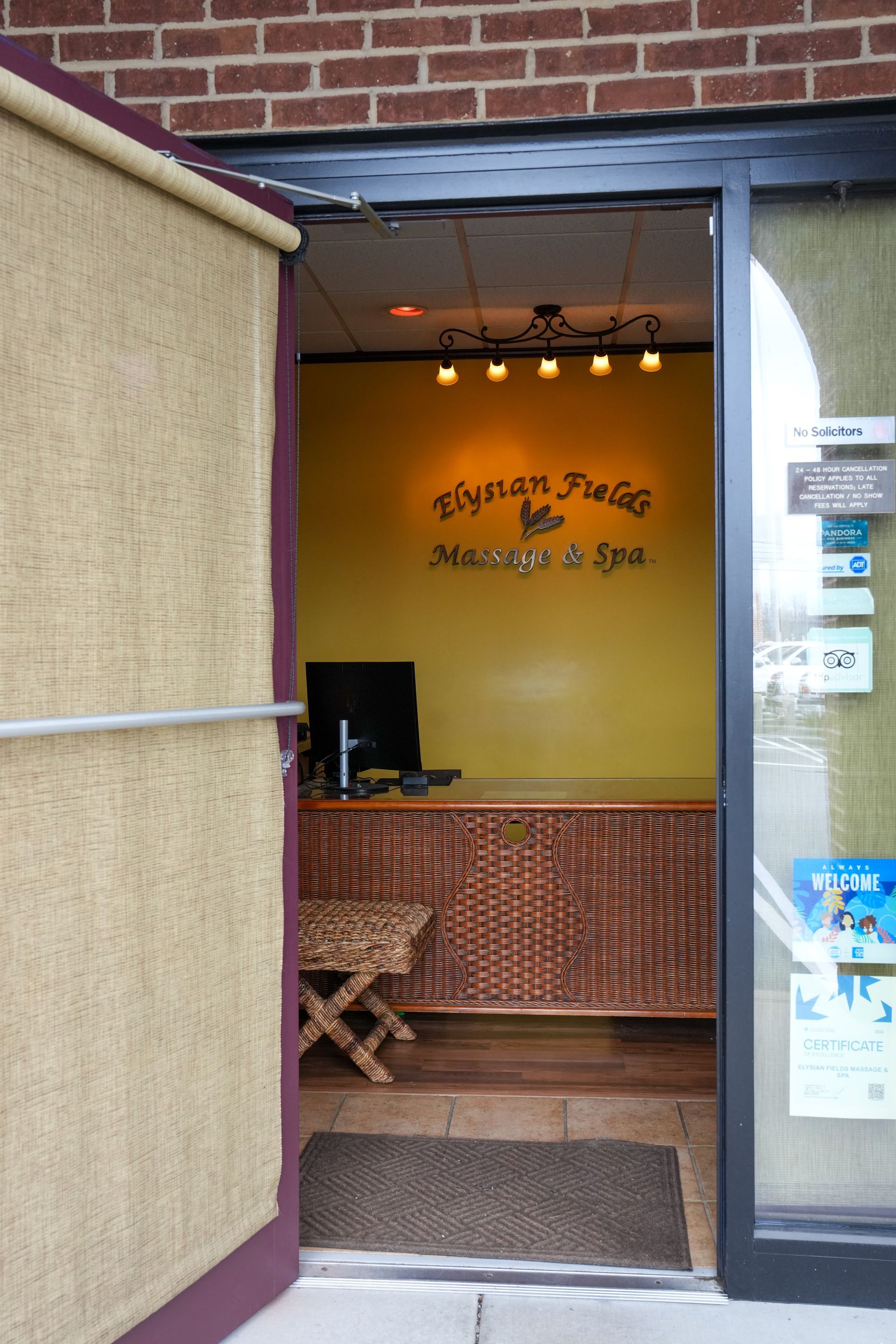 Open doorway to a small café with yellow walls, brick trim, and a counter inside.