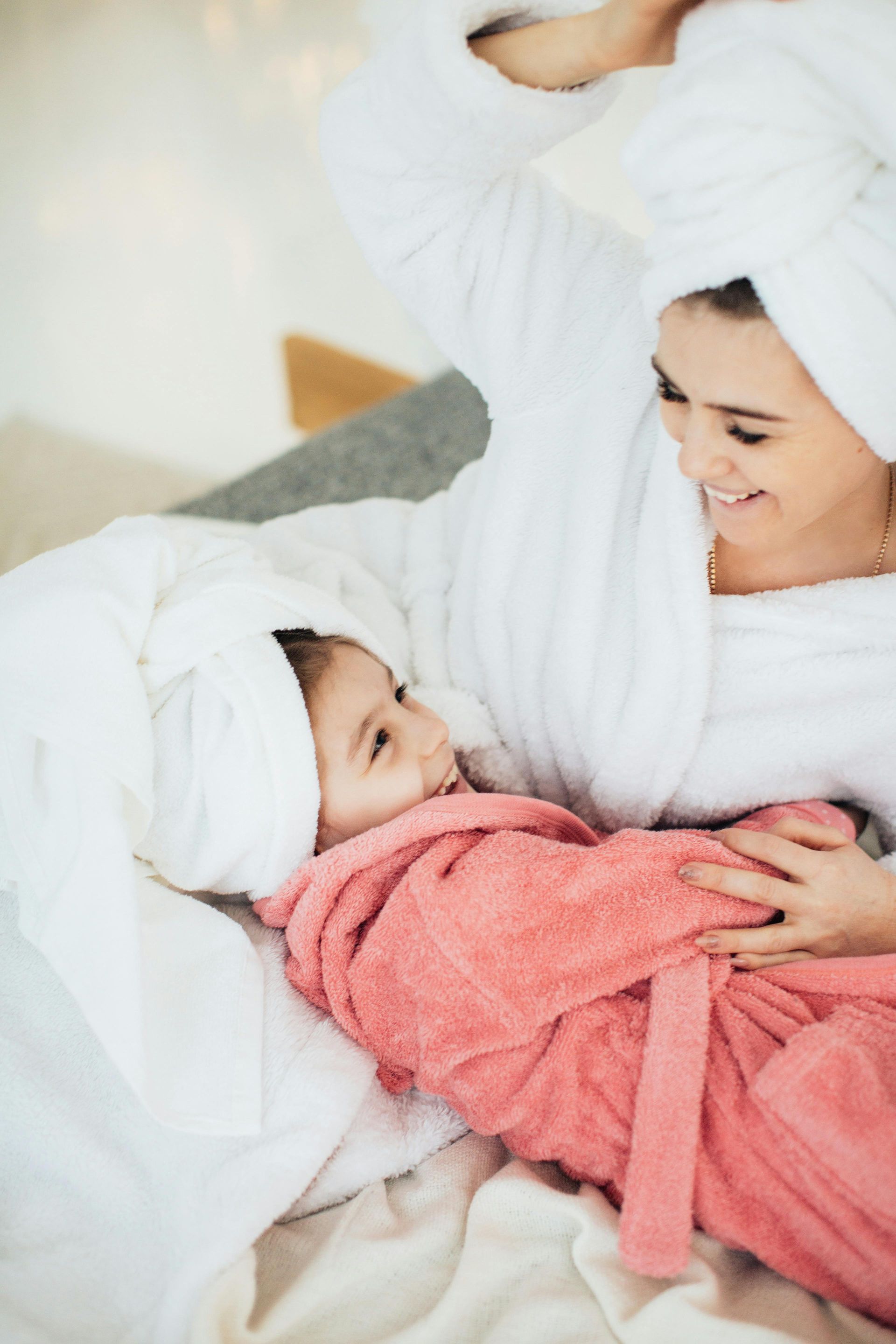 Pink torn paper revealing a woman’s nose and glossy lips against a pale pink background