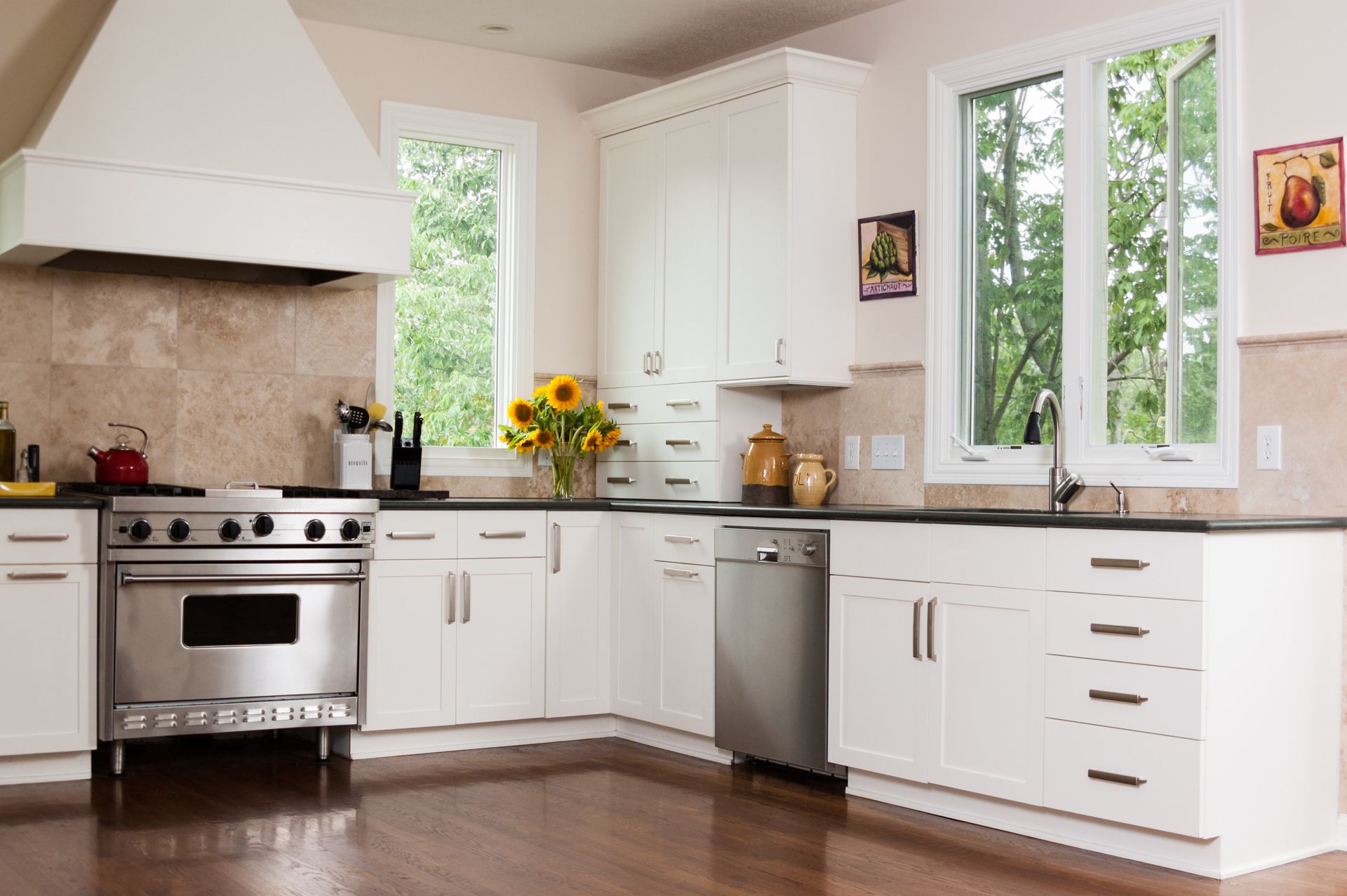 A kitchen with stainless steel appliances and white cabinets.
