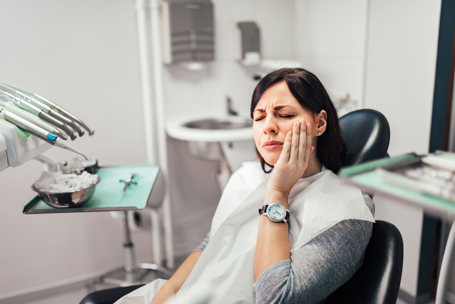A woman is at a dental office with a toothache.