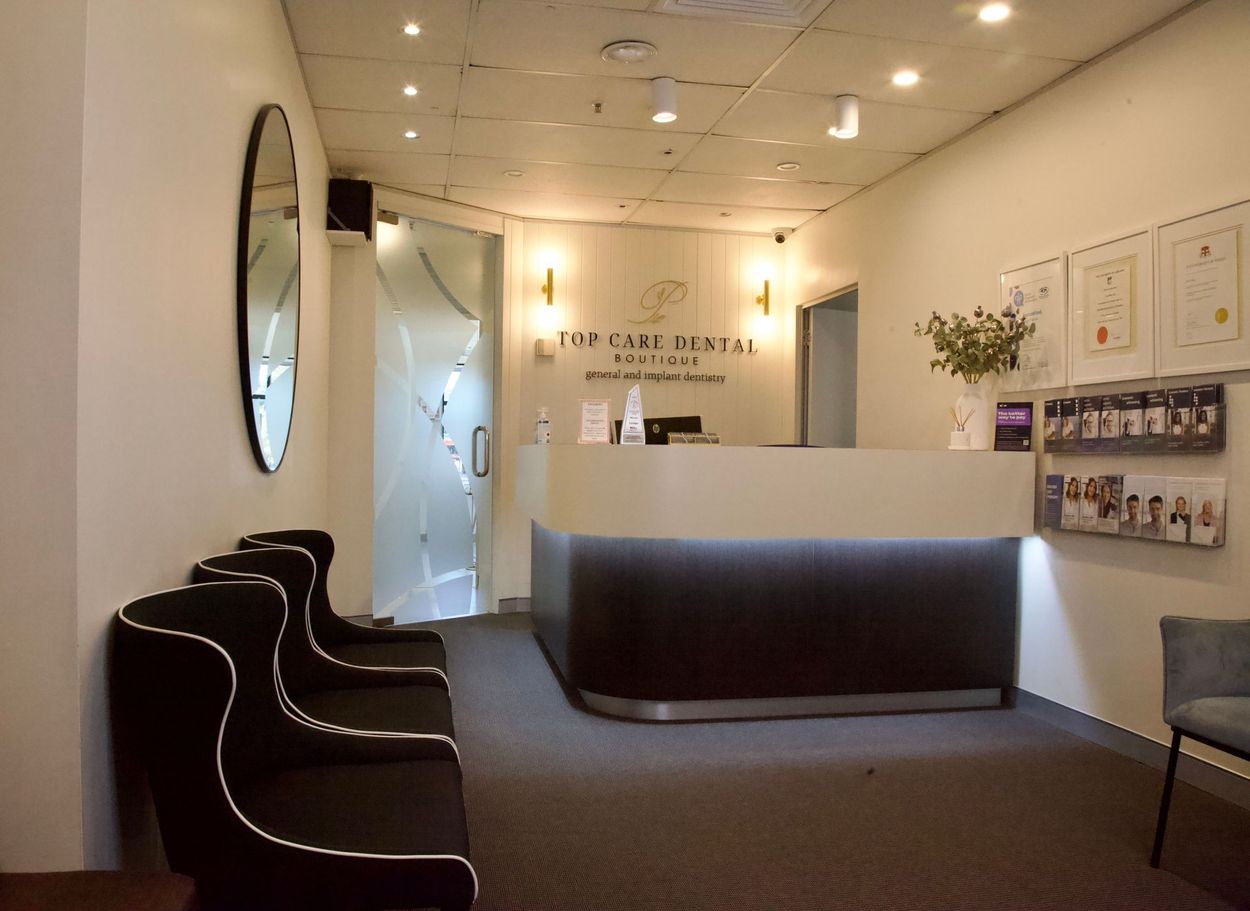 A waiting room in a dental office with chairs and a counter