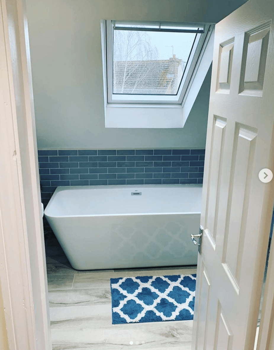 A bathroom with a bathtub and a skylight above it