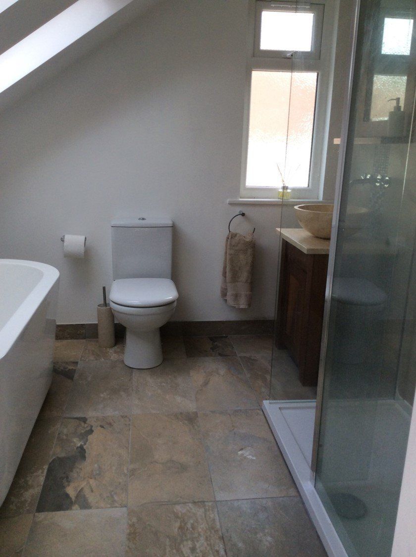 A bathroom with a toilet a bathtub and a shower