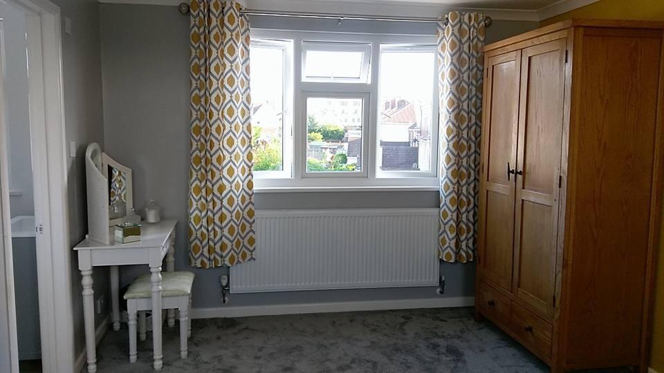 A loft bedroom with a dressing table , wardrobe, and window.