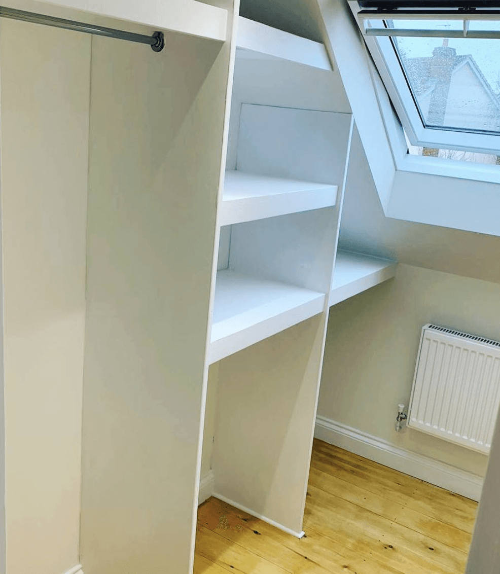 A walk in closet with a skylight and a window.