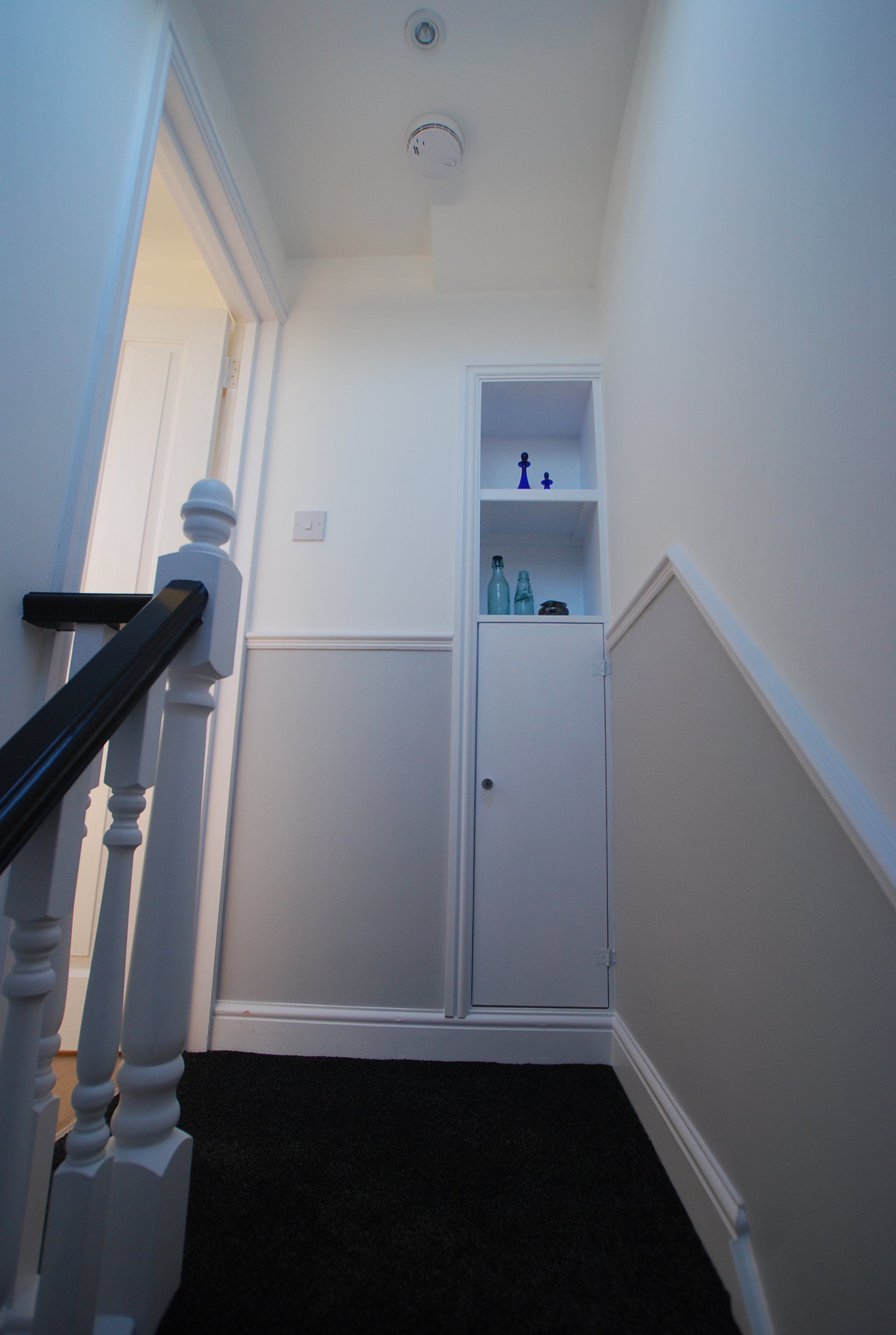 A hallway with a staircase leading up to the second floor