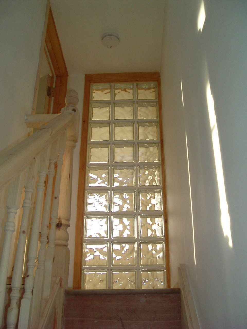 A staircase with a glass block wall in the middle