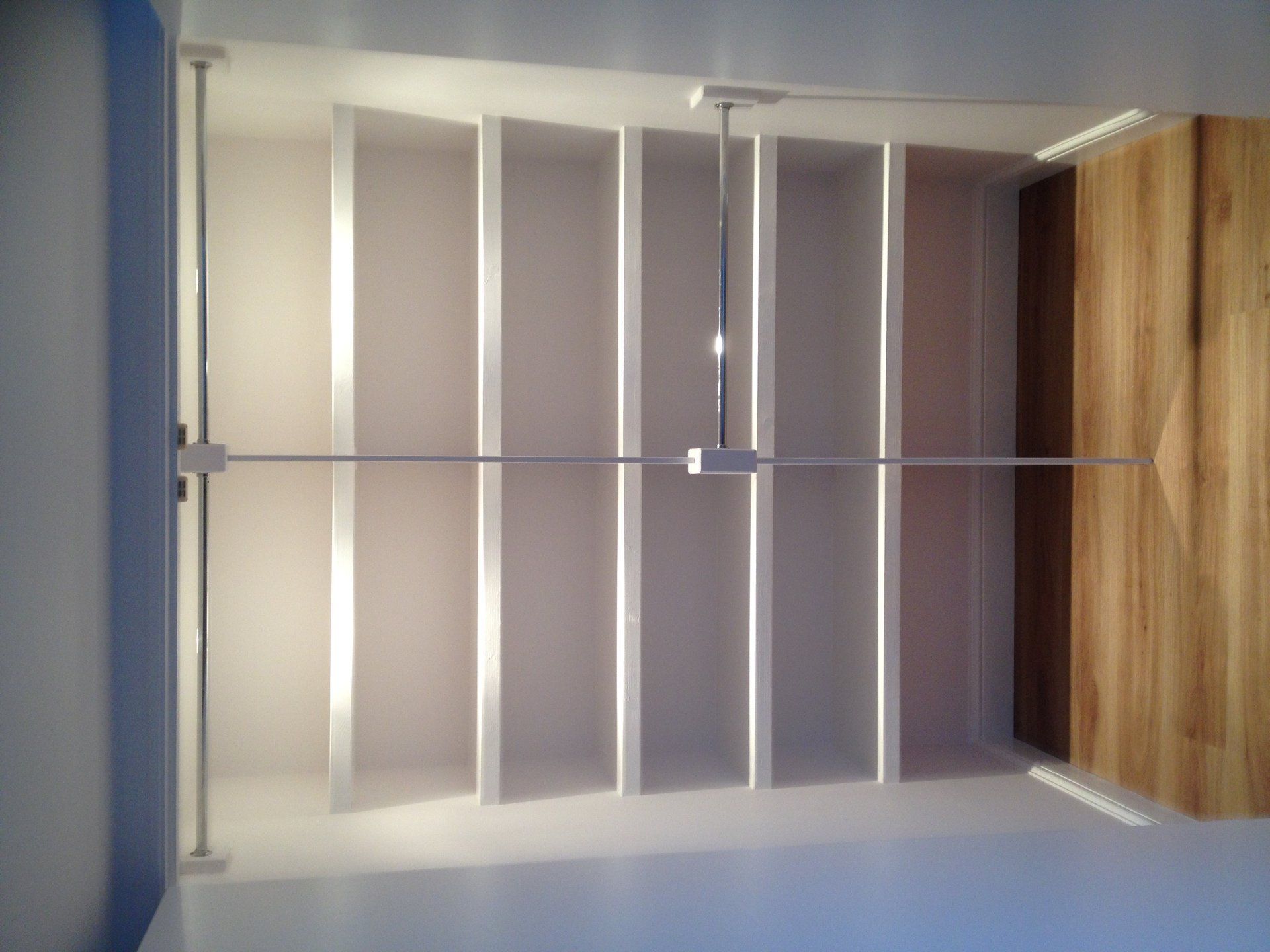 A ceiling fan is hanging from the ceiling above a set of shelves