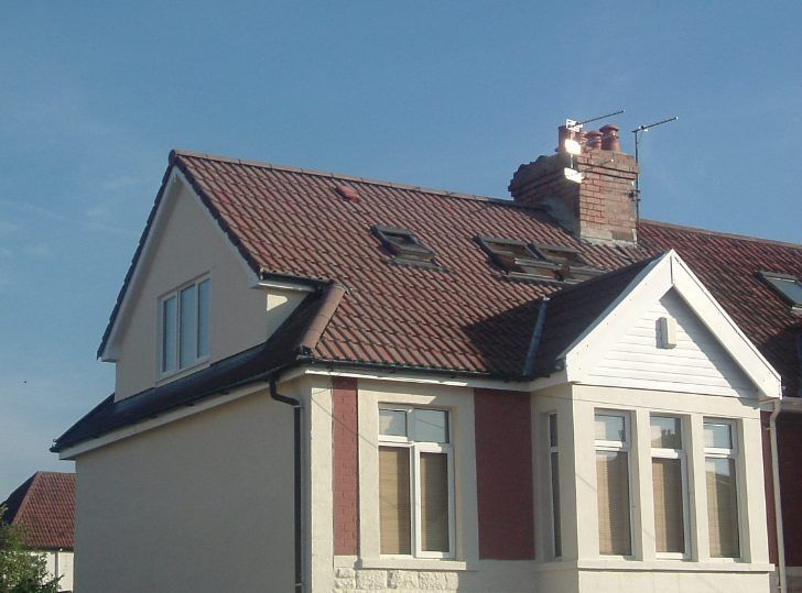 A house with a red tiled roof and a chimney