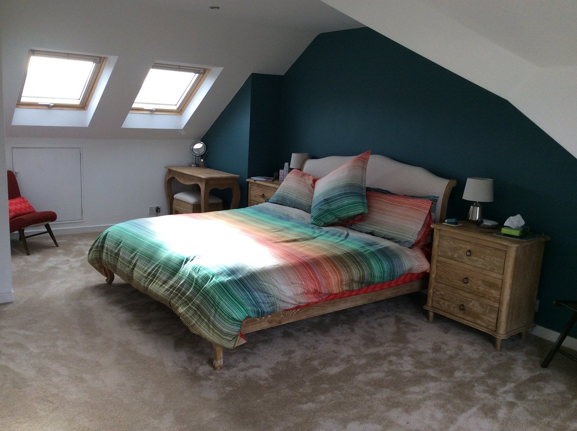 A bedroom with a bed , nightstands , and a chair.