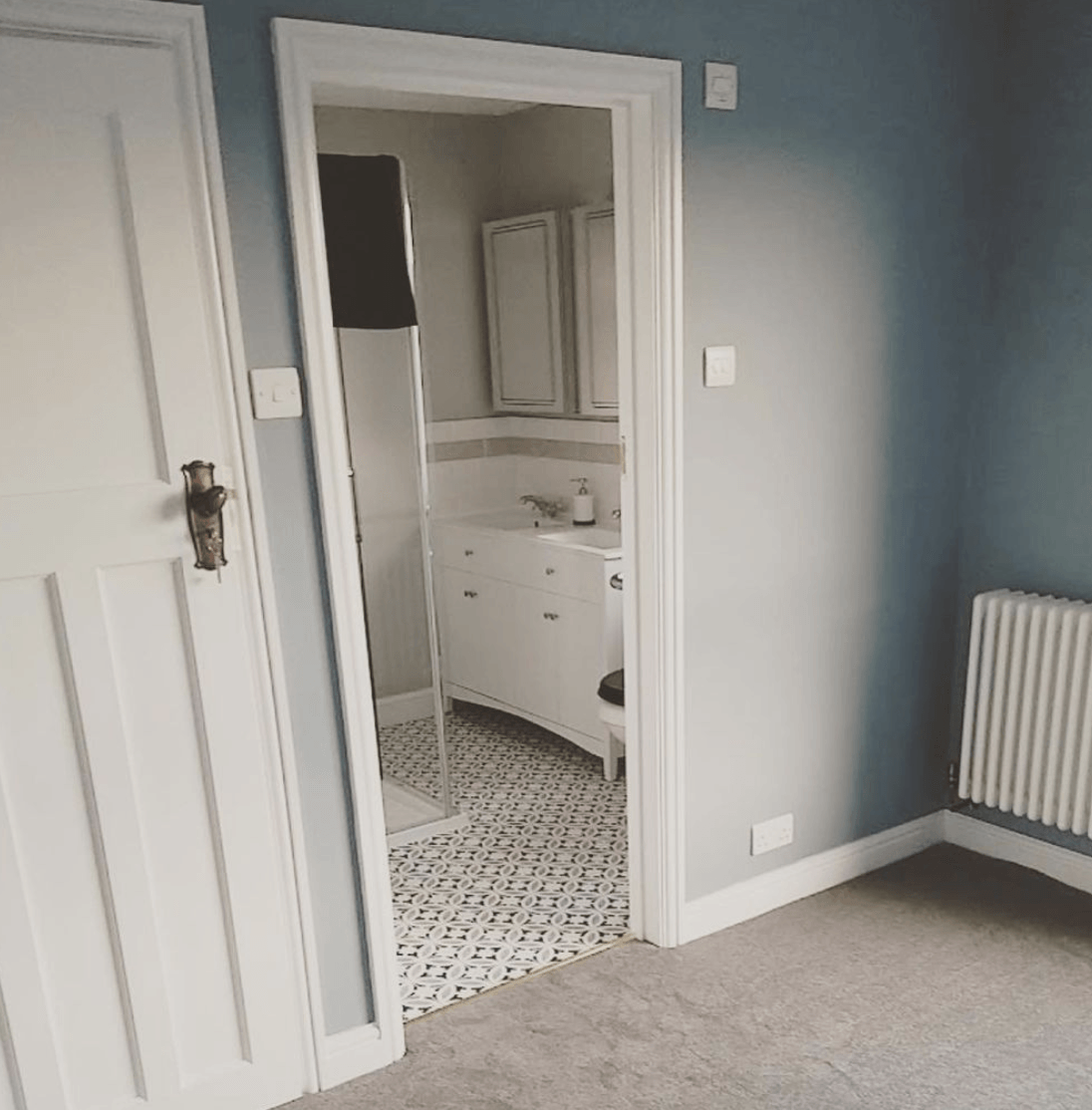 A room with a door that leads to a bathroom  in a new loft conversion