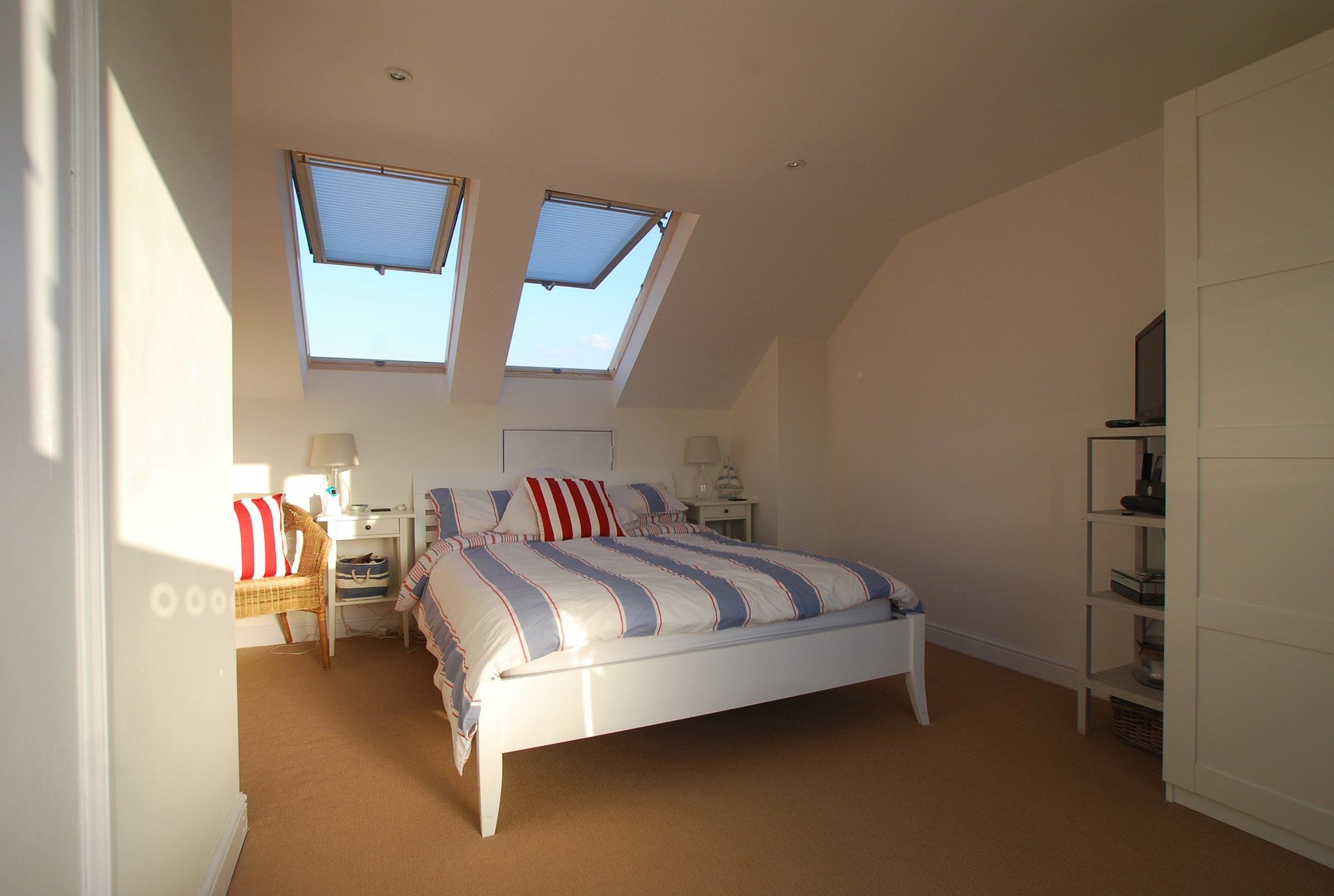 A main loft bedroom with a king-size bed and two Velux skylights
