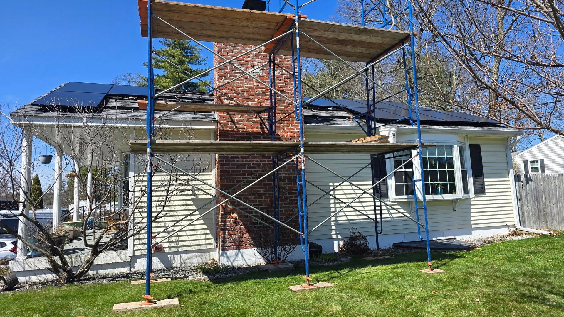 A house is being remodeled with scaffolding around the chimney.