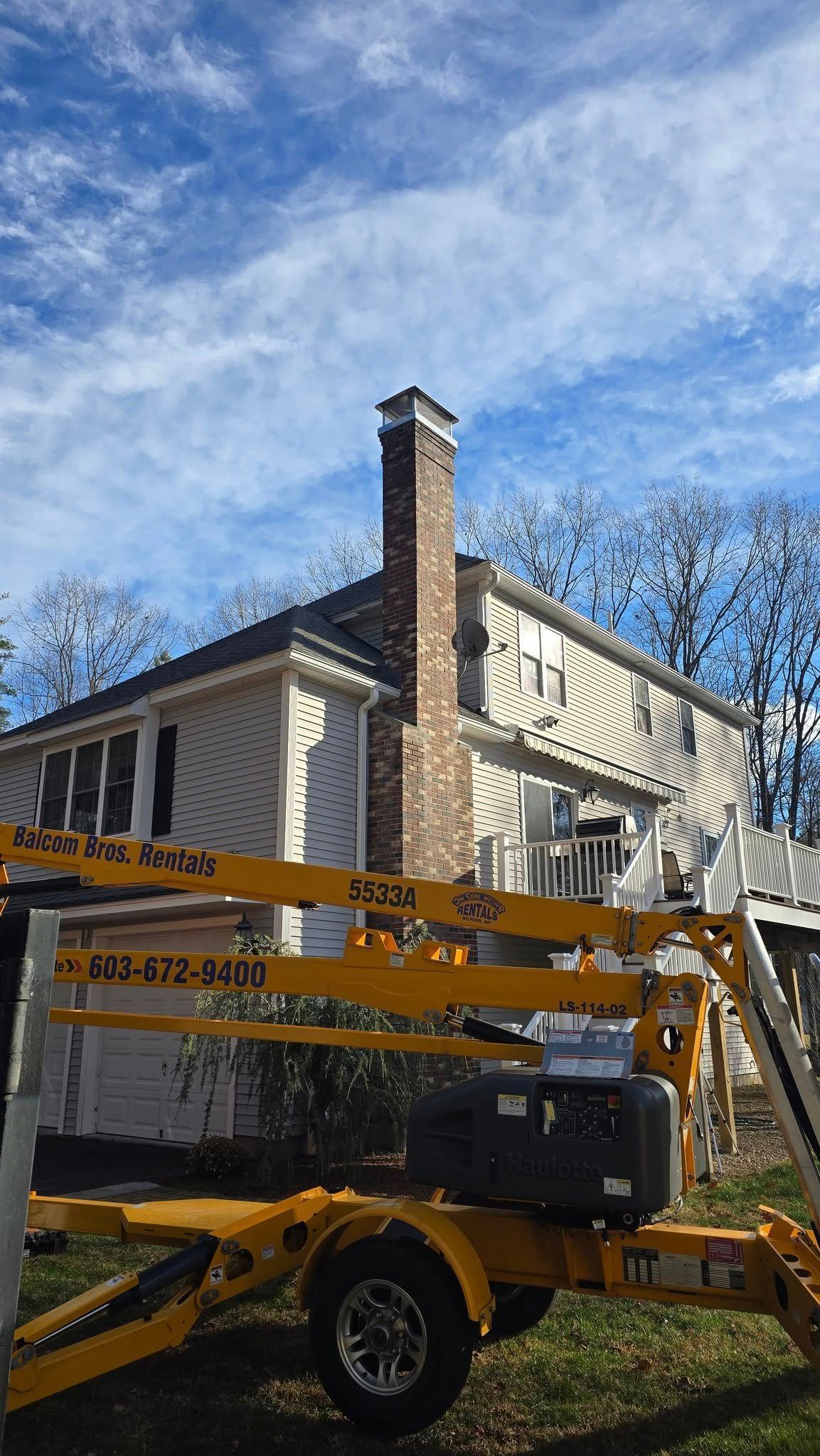 A yellow crane is parked in front of a house.