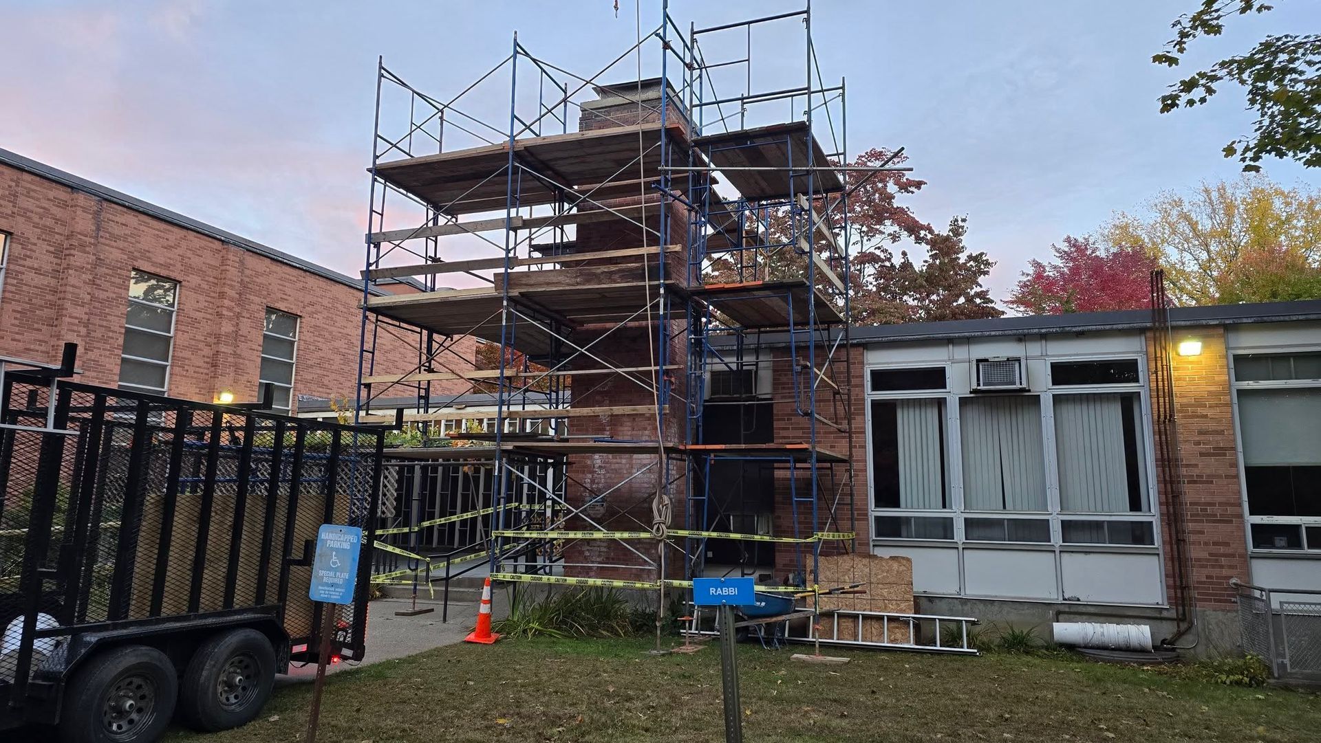 A truck is parked in front of a building with scaffolding on it.