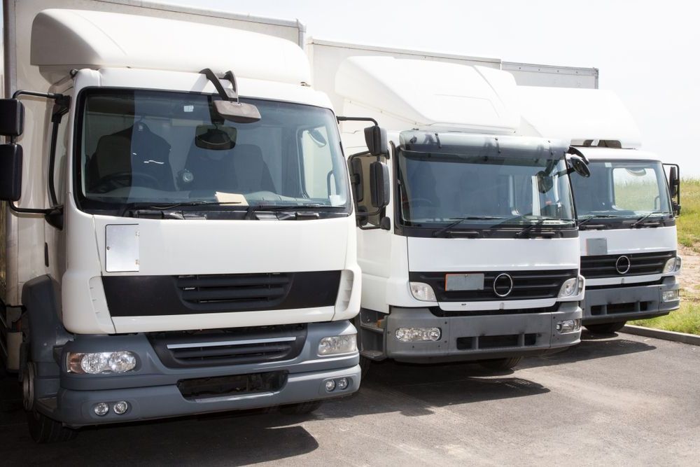 Three White Trucks Are Parked Next to Each Other in a Parking Lot — R2B Heavy Vehicle Driving School In Moranbah, QLD